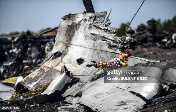 This photo taken on July 26, 2014 shows flowers, left by parents of an Australian victim of the crash, laid on a piece of the Malaysia Airlines plane...