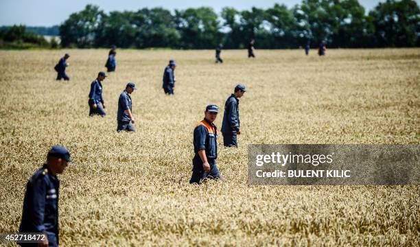 Members of the Ukrainian State Emergency Service search for bodies in a field near the crash site of the Malaysia Airlines Flight MH17 near the...