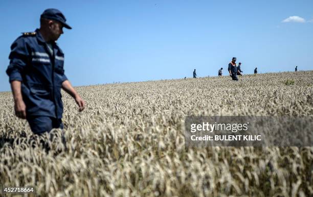 Members of the Ukrainian State Emergency Service search for bodies in a field near the crash site of the Malaysia Airlines Flight MH17 near the...