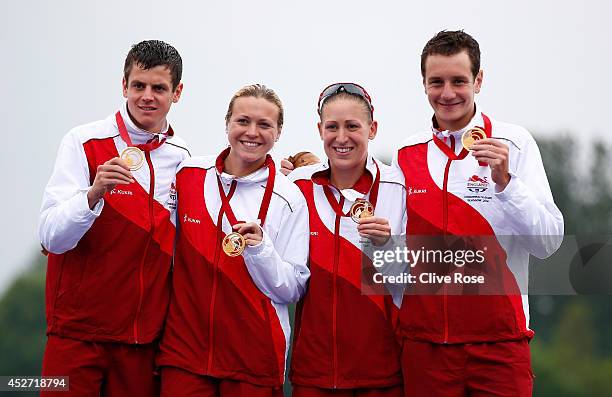 Jonathan Brownlee, Jody Simpson, Vicky Holland and Alistair Brownlee of England pose with their Gold medal on the podium after winning the mixed team...