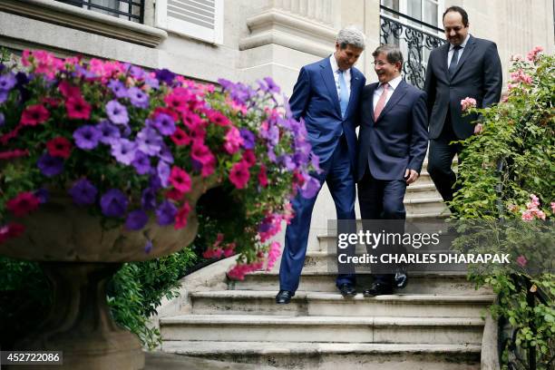 Secretary of State John Kerry speaks to Turkish Foreign Minister Ahmet Davutoglu and Qatari Foreign Minister Khaled al-Attiyah as they walk down the...