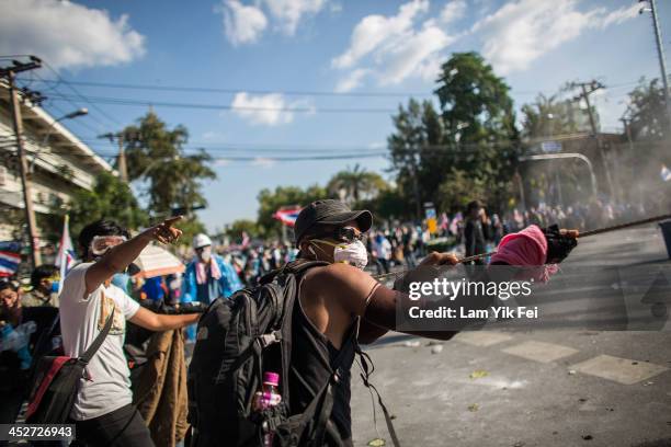 Anti-government protesters remove part of a barricade as they attempt to occupy the government house on December 1, 2013 in Bangkok, Thailand....