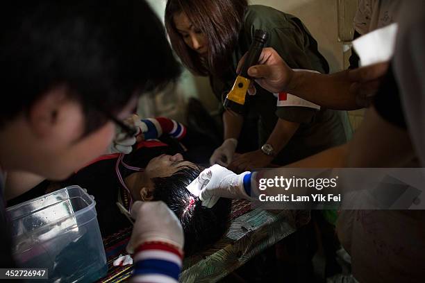 An anti-government protester injured after riot police fire tear gas on December 1, 2013 in Bangkok, Thailand. Anti-government protesters in Bangkok...