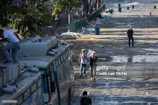 Anti-government protesters escape after riot police fire tear gas on December 1, 2013 in Bangkok, Thailand. Anti-government protesters in Bangkok say...