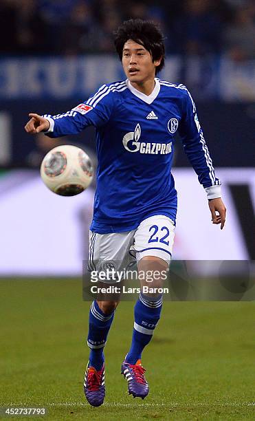Atsuto Uchida of Schalke runs with the ball during the Bundesliga match between FC Schalke 04 and VfB Stuttgart at Veltins-Arena on November 30, 2013...