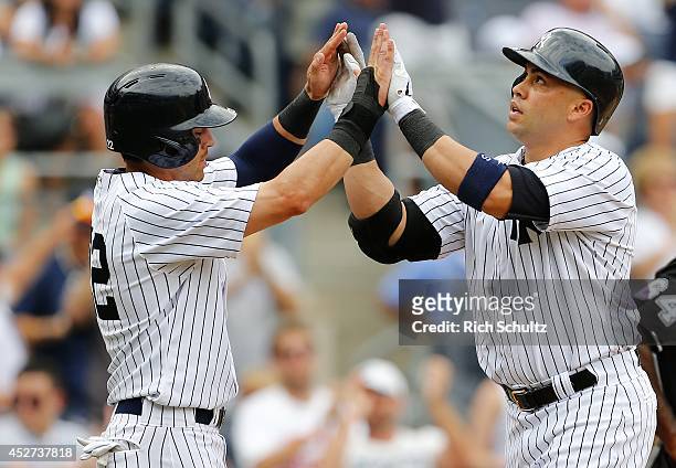Carlos Beltran of the New York Yankees is congratulated by teammate Jacoby Ellsbury after hitting a two-run home run in the ninth inning during an...