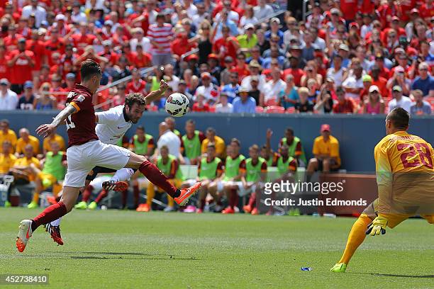 Juan Mata of Manchester United scores past Alessio Romangnoli and goalkeeper Lukasz Skorupski of AS Roma during the first half of an International...