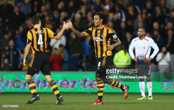 Tom Huddlestone of Hull City celebrates his team's third goal, an own goal by Martin Skrtel of Liverpool, with Alex Bruce during the Barclays Premier...