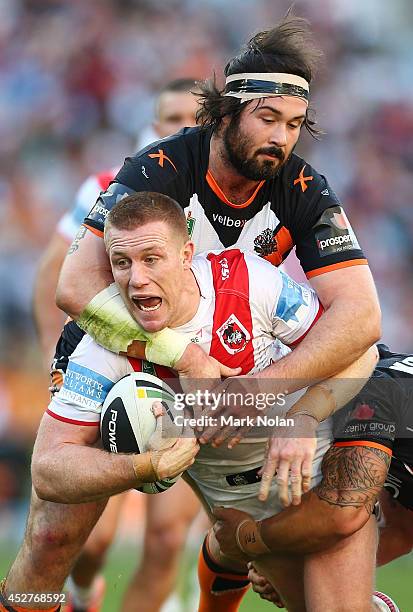 Aaron Woods of the Tigers tackles Ben Creagh of the Dragons during the round 20 NRL match between the Wests Tigers and the St George Illawarra...