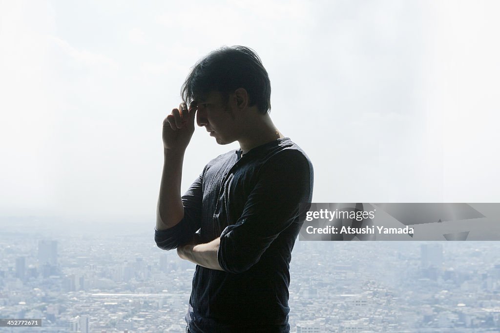 Man depressing, cityscape in background