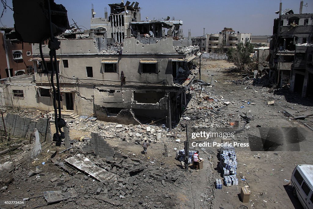 Palestinians inspect the rubble of destroyed houses in the...