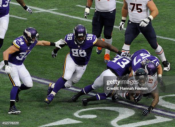 Brandon Marshall of the Chicago Bears is tackled by Audie Cole and Jamarca Sanford of the Minnesota Vikings during the first quarter of the game on...