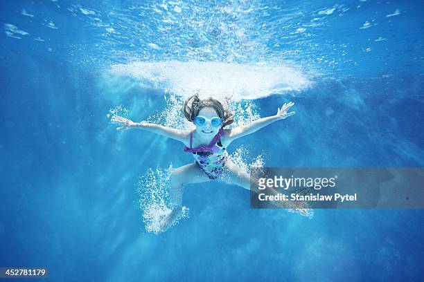 small girl jumping into water- underwater view - kid under water stock-fotos und bilder