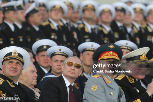 Russian President Vladimir Putin and Defence Minister Sergei Shoigu watch the Navy Day Military parade July 27, 2014 in Severomorsk. Putin is having...