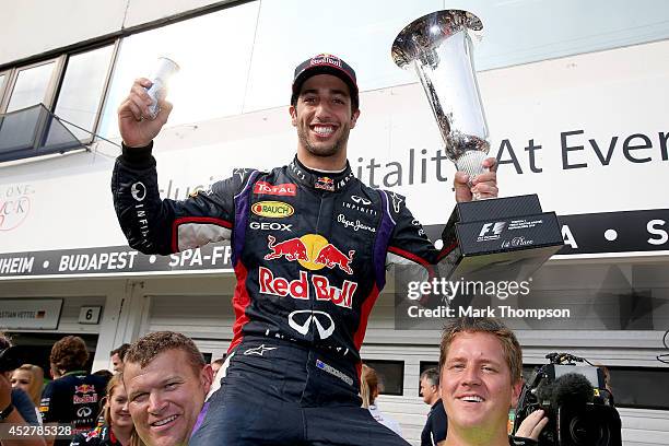 Daniel Ricciardo of Australia and Infiniti Red Bull Racing celebrates victory with the trophy in the pit lane after the Hungarian Formula One Grand...