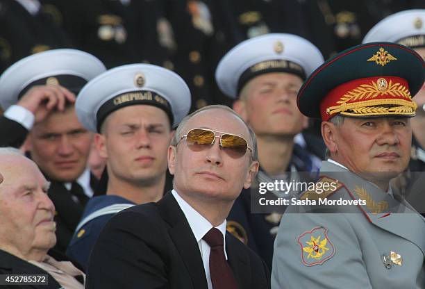 Russian President Vladimir Putin and Defence Minister Sergei Shoigu watch the Navy Day Military parade July 27, 2014 in Severomorsk. Putin is having...