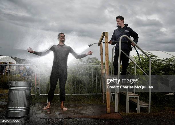 An entrant is hosed down in the 'shower cubicle' after takes part in the Irish Bog Snorkelling championship this afternoon at Peatlands Park on July...