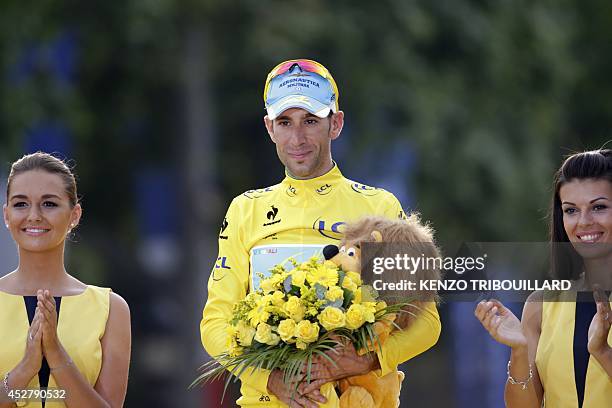 Italy's Vincenzo Nibali poses with his overall leader yellow jersey on the podium on the Champs-Elysees avenue in Paris, at the end of the 137.5 km...