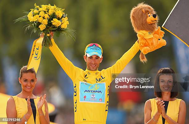 Vincenzo Nibali of Italy and Astana Pro Team celebrates victory in the yellow jersey on the podium following the twenty first stage of the 2014 Tour...