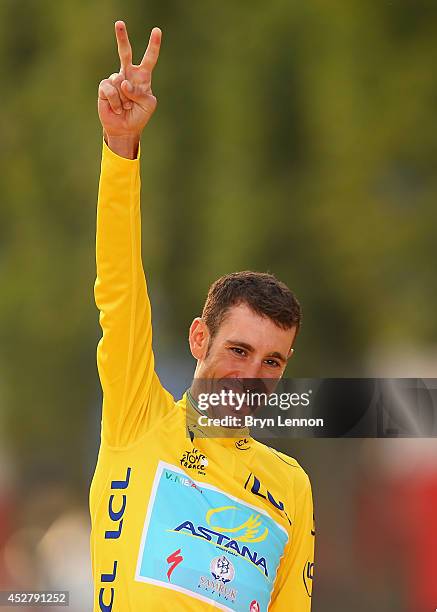 Vincenzo Nibali of Italy and Astana Pro Team celebrates victory in the yellow jersey on the podium following the twenty first stage of the 2014 Tour...