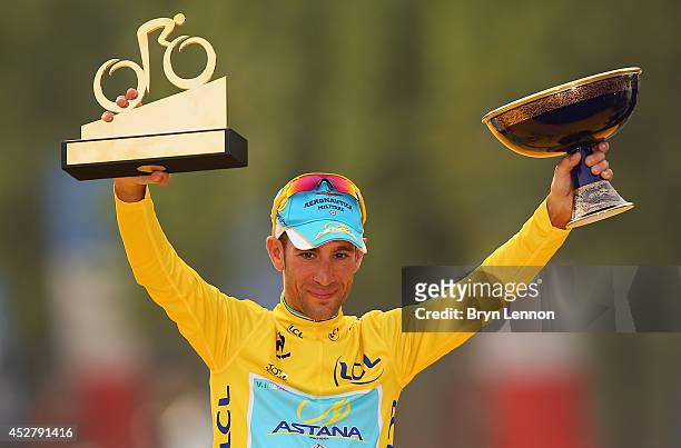 Vincenzo Nibali of Italy and Astana Pro Team celebrates victory in the yellow jersey on the podium following the twenty first stage of the 2014 Tour...