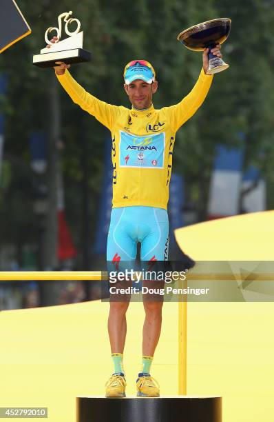 Vincenzo Nibali of Italy and Astana Pro Team celebrates victory in the yellow jersey on the podium following the twenty first stage of the 2014 Tour...