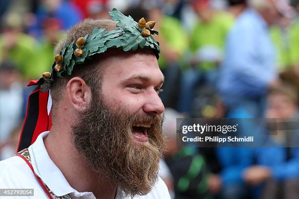 Wreath crowned Swiss Alpine wrestler Benji von Ah smiles after the Alpine Wrestling Festival Bruenig-Schwinget at the top of the Bruenig Pass on July...