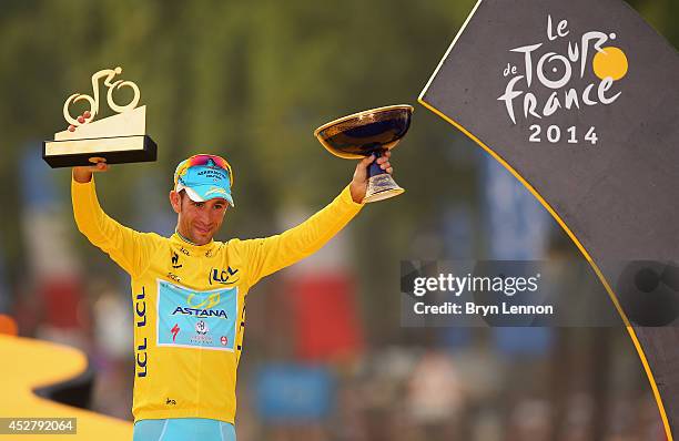 Vincenzo Nibali of Italy and Astana Pro Team celebrates victory in the yellow jersey on the podium following the twenty first stage of the 2014 Tour...