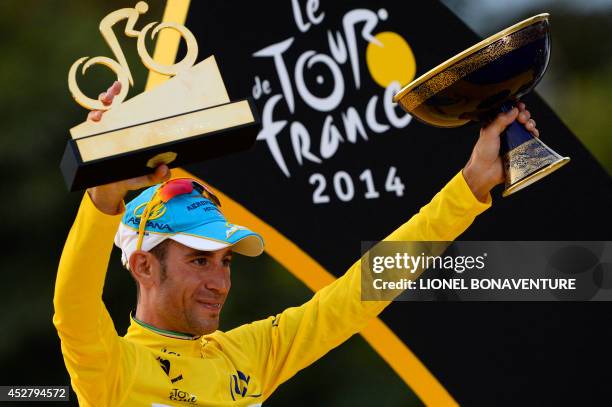 Tour de France 2014's winner Italy's Vincenzo Nibali celebrates with his trophies on the podium on the Champs-Elysees avenue in Paris, at the end of...