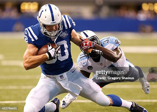 Coby Fleener of the Indianapolis Colts works for extra yards after a fourth quarter catch in front of Bernard Pollard of the Tennessee Titans at...