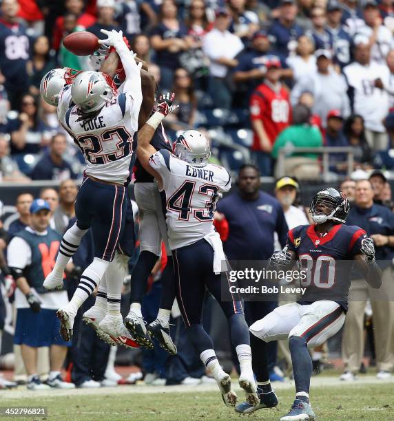 Marquice Cole of the New England Patriots has the ball go through his hands on the last play of the game as Andre Johnson of the Houston Texans looks...