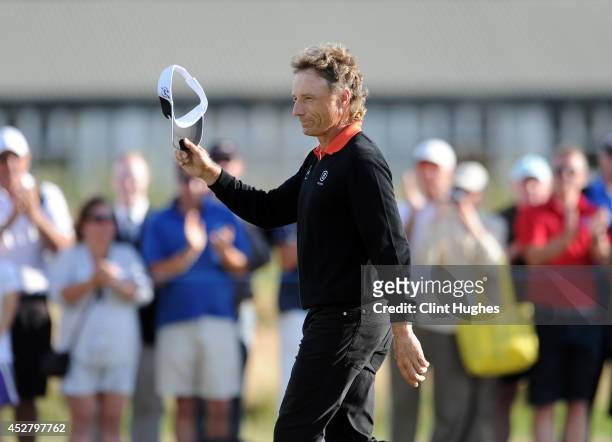 Bernhard Langer of Germany waves to the crowd as he walks up the fairway on the 18th hole during the fourth round of the Senior Open Championship at...
