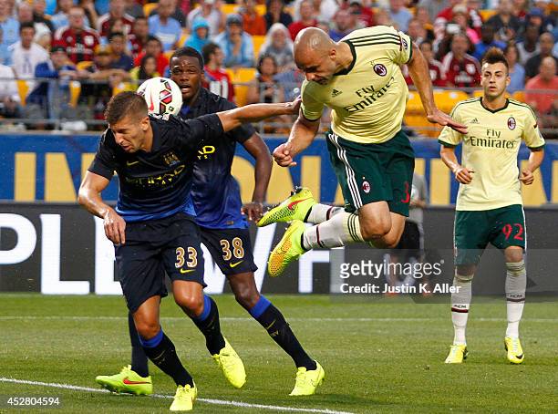 Alex Rodrigo Dias da Costa of AC Milan heads a ball in the first half against Matija NastasiÄ of Manchester City during International Champions Cup...