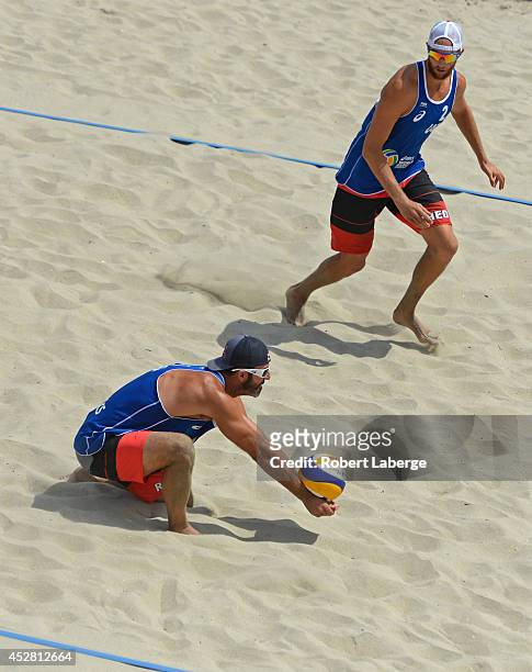 Todd Rogers of the United States digs the Mikasa as Theodore Brunner looks on during the bronze medal match during the FIVB Long Beach Grand Slam on...