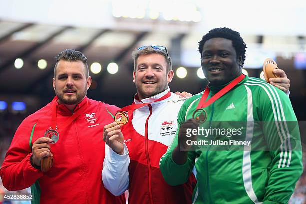 Silver medallist Aled Davies of Wales, gold medallist Dan Greaves of England and bronze medallist Richard Okigbazi of Nigeria stand on the podium...