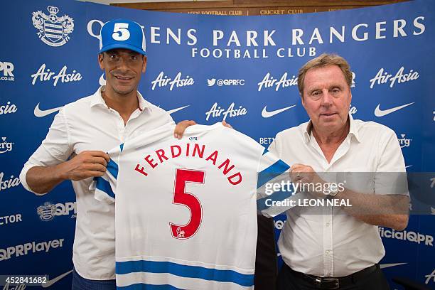 Queens Park Rangers English player Rio Ferdinand and manager Harry Redknapp pose for photographs during a press conference at the Queens Park Rangers...