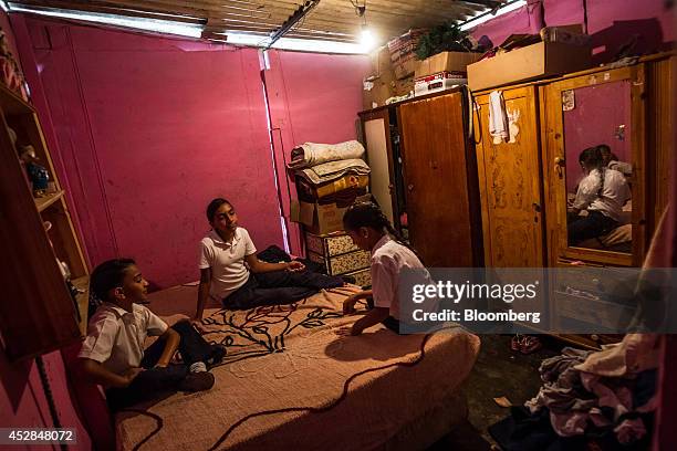 Sisters Natali Graterol center, Niurka Susana Graterol left, and Edith Yorleni Graterol sit in their bedrom in their home constructed of sheet metal...