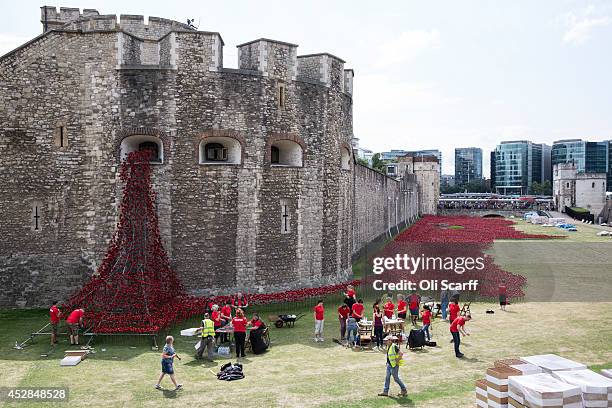 Volunteers assemble an installation entitled 'Blood Swept Lands and Seas of Red' by artist Paul Cummins, made up of 888,246 ceramic poppies in the...