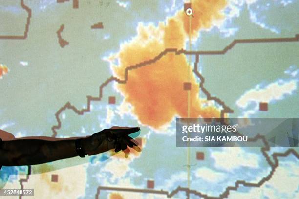 Member of Burkina Faso's crisis centre for the crash of the Air Algerie flight AH5017 points to a weather map on a screen on July 28, 2014 in the...