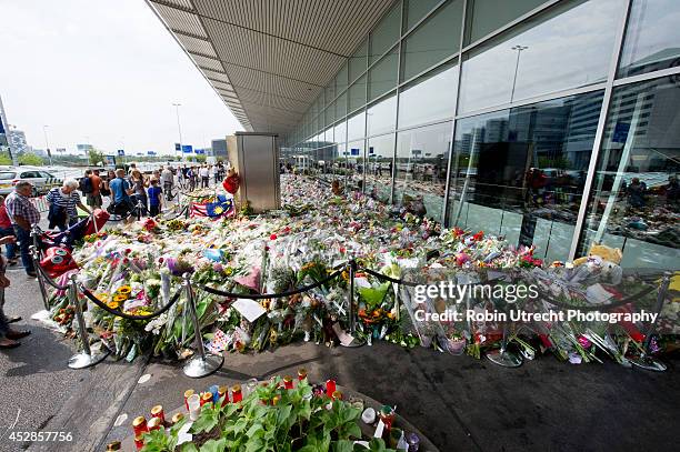 Flowers and candle tributes are left to commemorate the victims of Malaysian Airlines flight MH17 at Schiphol Amsterdam Airport on July 28, 2014 near...