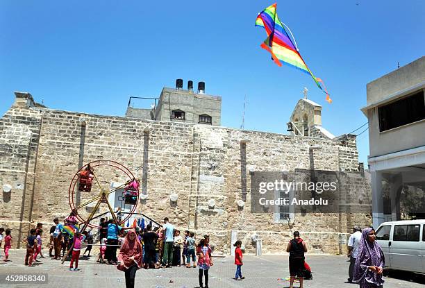 Gazaian Muslims sheltering at the Greek Orthodox Church, try to make the most of their Eid al-Fitr celebrations on July 2014. During normal times,...