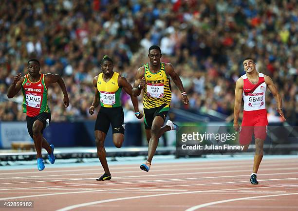 Kemar Bailey-Cole of Jamaica crosses the line to win gold ahead of silver medalist Adam Gemili of England in the Mens 100 metres final at Hampden...