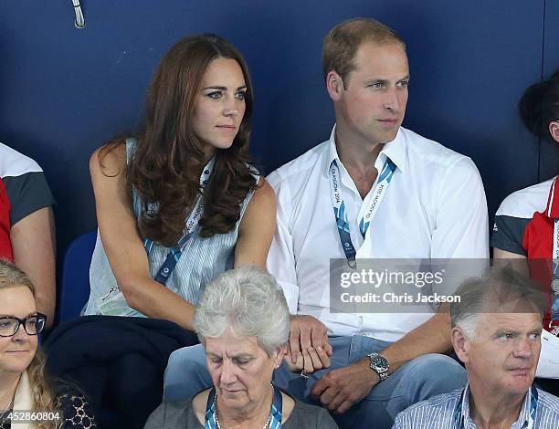 Catherine, Duchess of Cambridge and Prince William, Duke of Cambridge hold hands as they watch the swimming at Tollcross Swimming Centre during the...