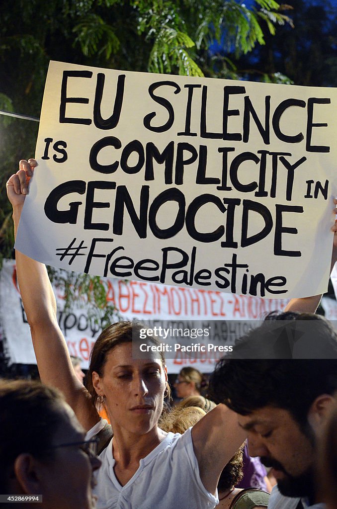 A woman holds a banner that reads "EU silence is complicity...