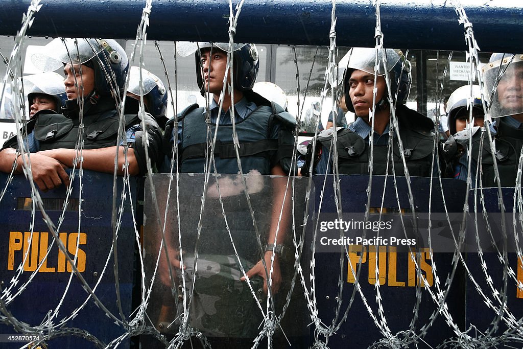 Crowd control police on stand-by behind razor wires along...