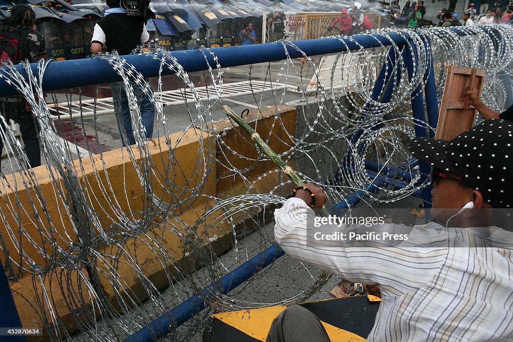 A protester tries to make a hole around the concertina razor...