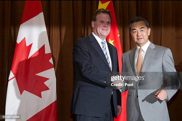 Canada's Foreign Minister John Baird shakes hands with Chinese Foreign Minister Wang Yi before a meeting at the Foreign Ministry on July 29, 2014 in...