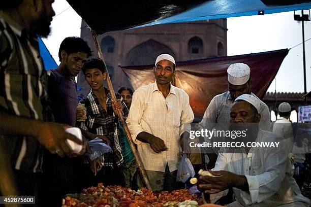 Indian Muslim vendors arrange fruits to sell to break the fast at Iftar on Chand Raat, the last evening of the holy Islamic month of Ramadan, outside...