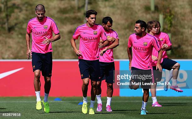 Gerard Piqué, Marc Bartra and Xavier of Barcelona in action during a Barcelona Training Session at St Georges Park on July 29, 2014 in...