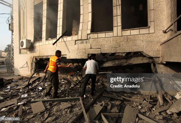 Palestinian firefighters try to extinguish fire on the rubble of a El-Emin Mohammed mosque after an Israeli air strike in Gaza City, Gaza on July 29,...